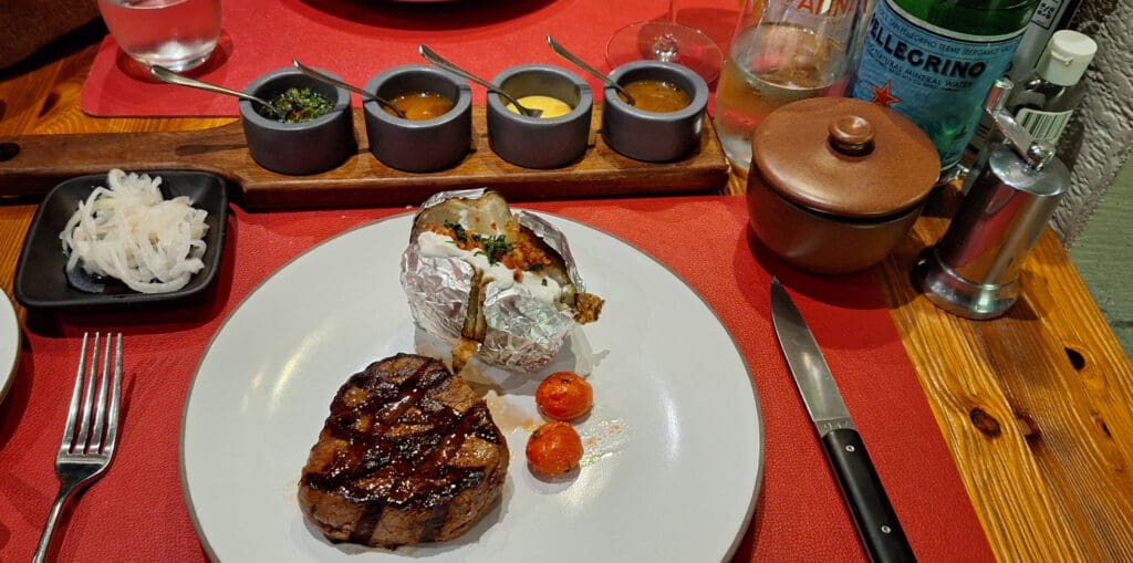 a plate of steak and baked potatoes