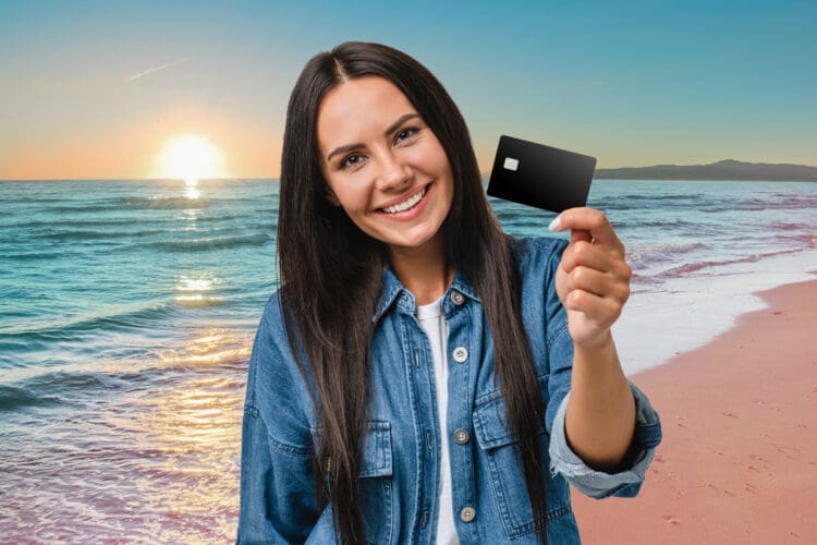 a woman holding a credit card on a beach