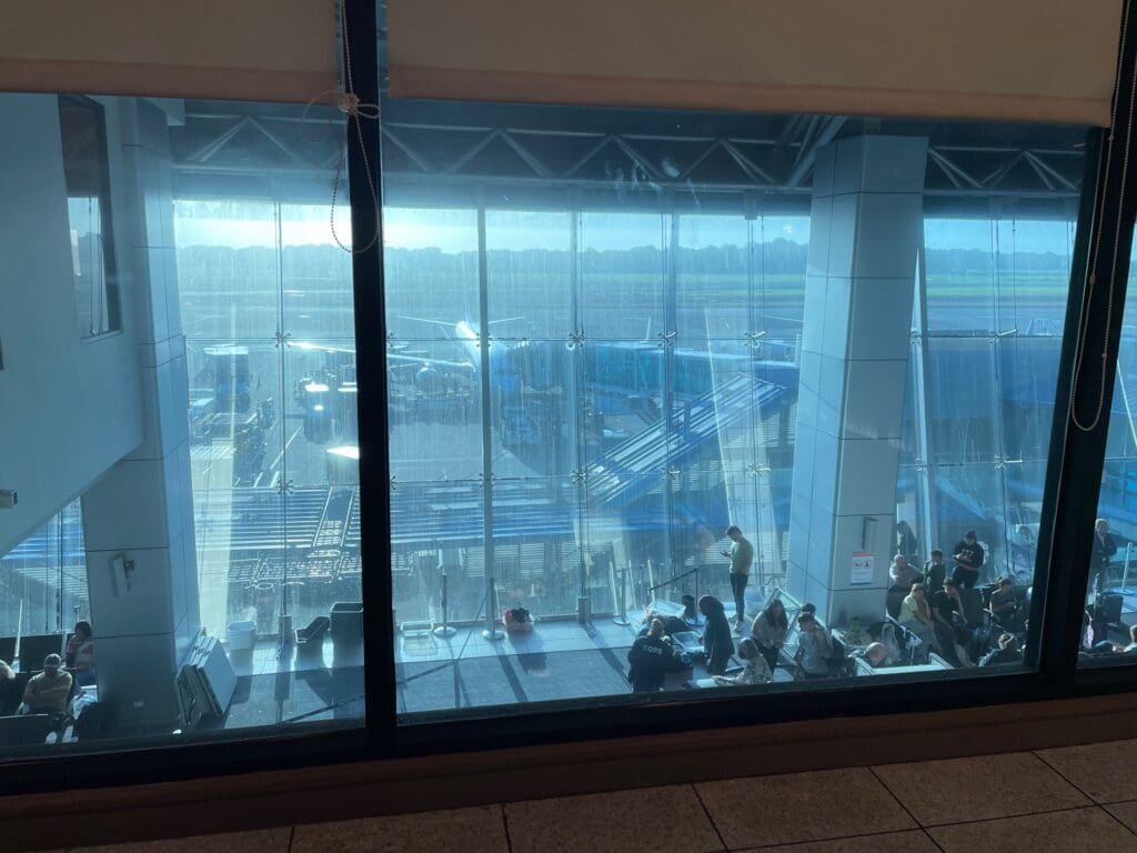 a group of people sitting in a room with large windows