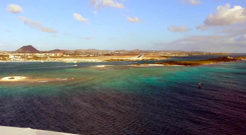 a body of water with land and buildings in the background