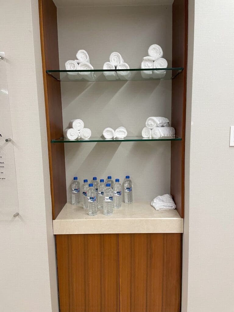 a shelf with towels and water bottles