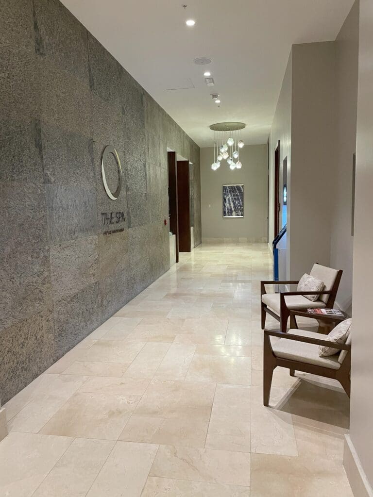 a hallway with chairs and a chandelier