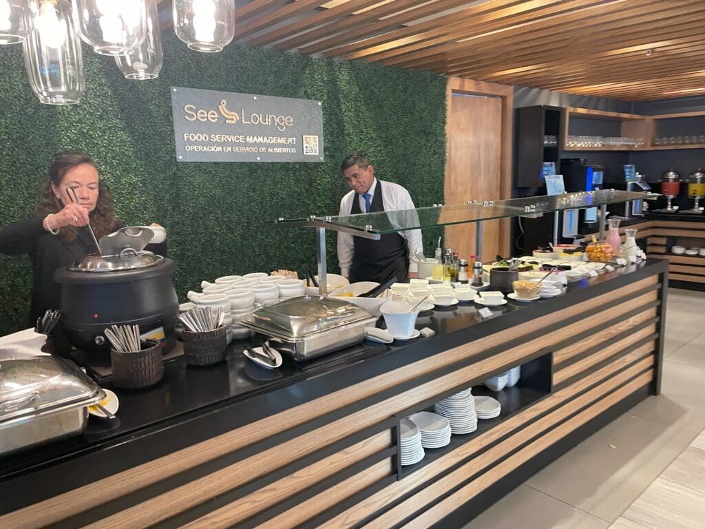 a man and woman standing behind a buffet