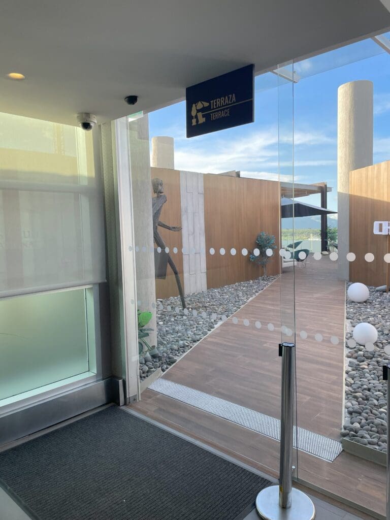 a glass door with a sign and a wood wall