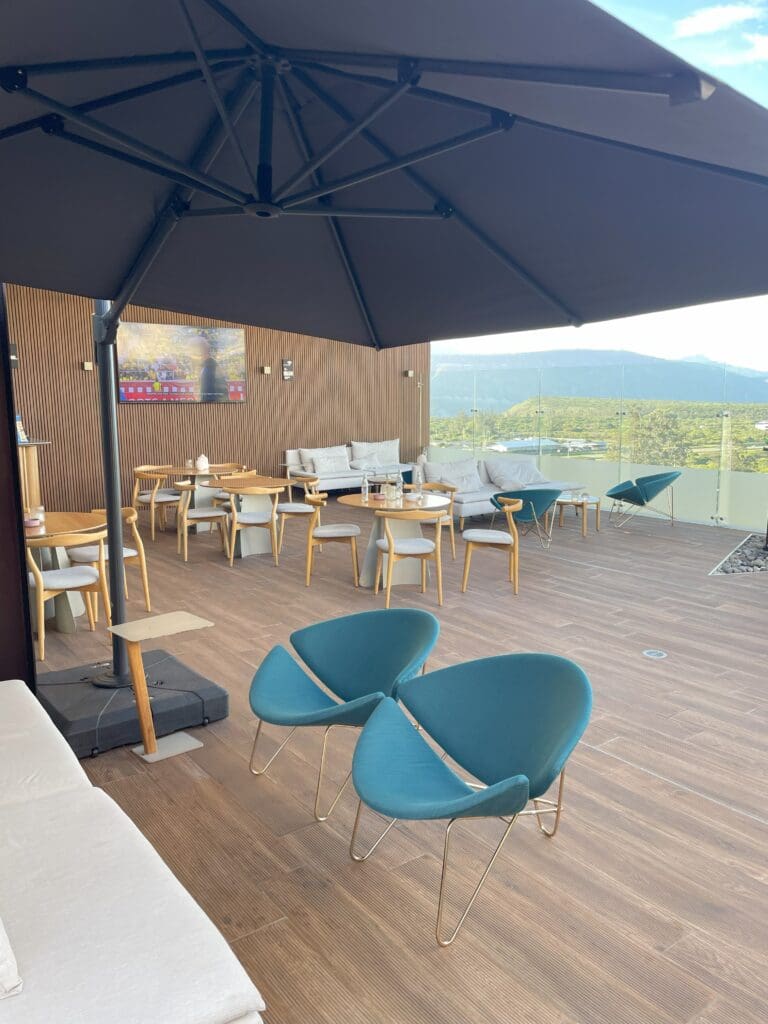 a patio with chairs and tables and umbrella