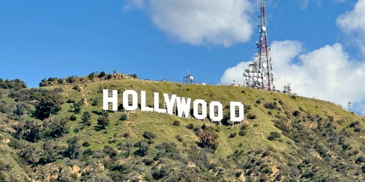 a sign on a hill with Hollywood Sign in the background