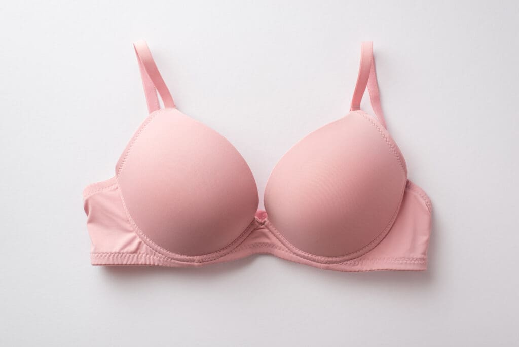 Breast cancer awareness concept. Top view photo of pink brassiere on isolated white background