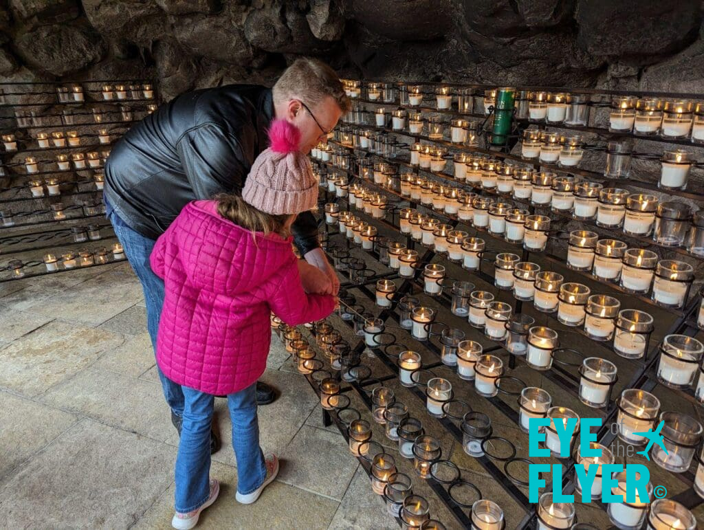 a man and girl standing in front of a group of candles
