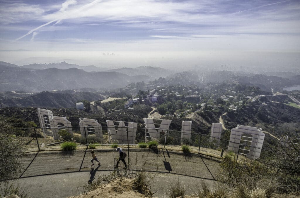 Los Angeles, CA, USA, October 25, 2013: A mother and child walk up Mount Lee Drive behind the Hollywood sign in Los Angeles, CA. (©iStock.com/GDMatt66)