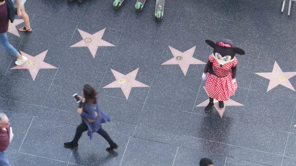 LOS ANGELES, CALIFORNIA, USA - 7 NOV 2019: Walk of fame promenade on Hollywood boulevard in LA. Pedastrians walking near celebrity stars on asphalt. Walkway floor near Dolby and TCL Chinese Theatre. (©iStock.com/DogoraSun)