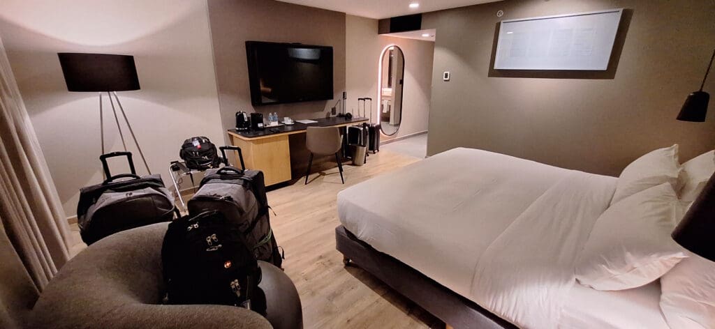 a room with a bed and a desk and luggage