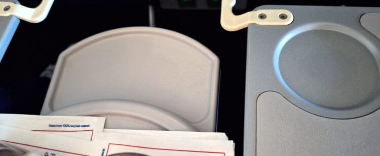 a white plate with a red border next to a grey object