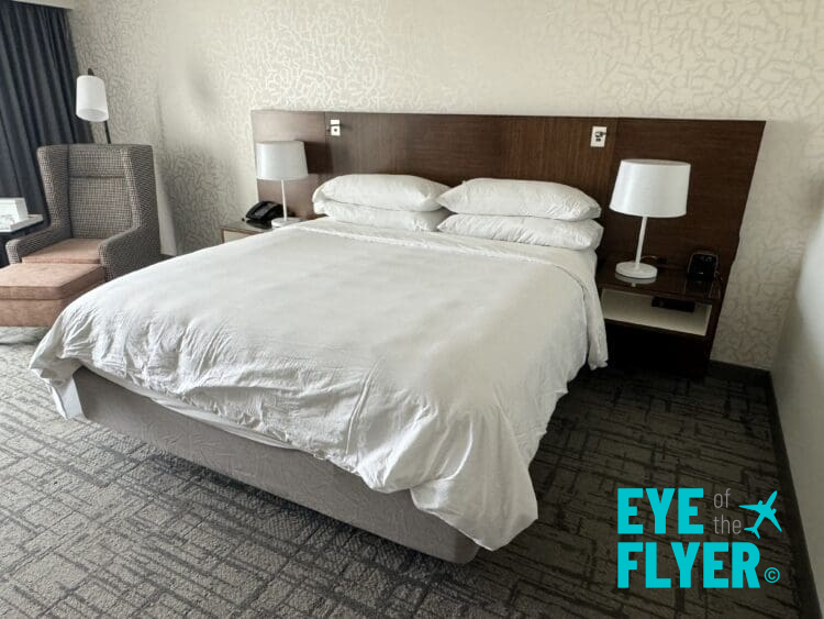 a bed with white sheets and a lamp