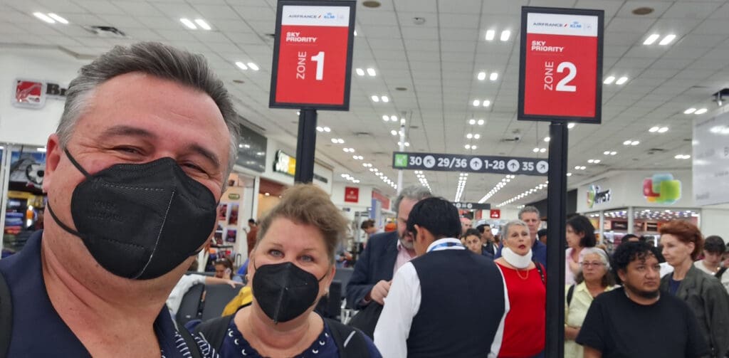 a man and woman wearing face masks in a airport