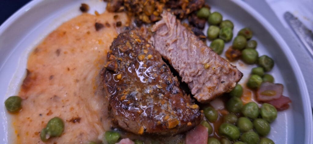 a plate of food with meat and peas