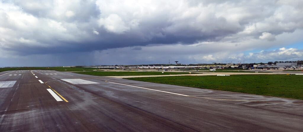 a runway with a lot of planes in the background