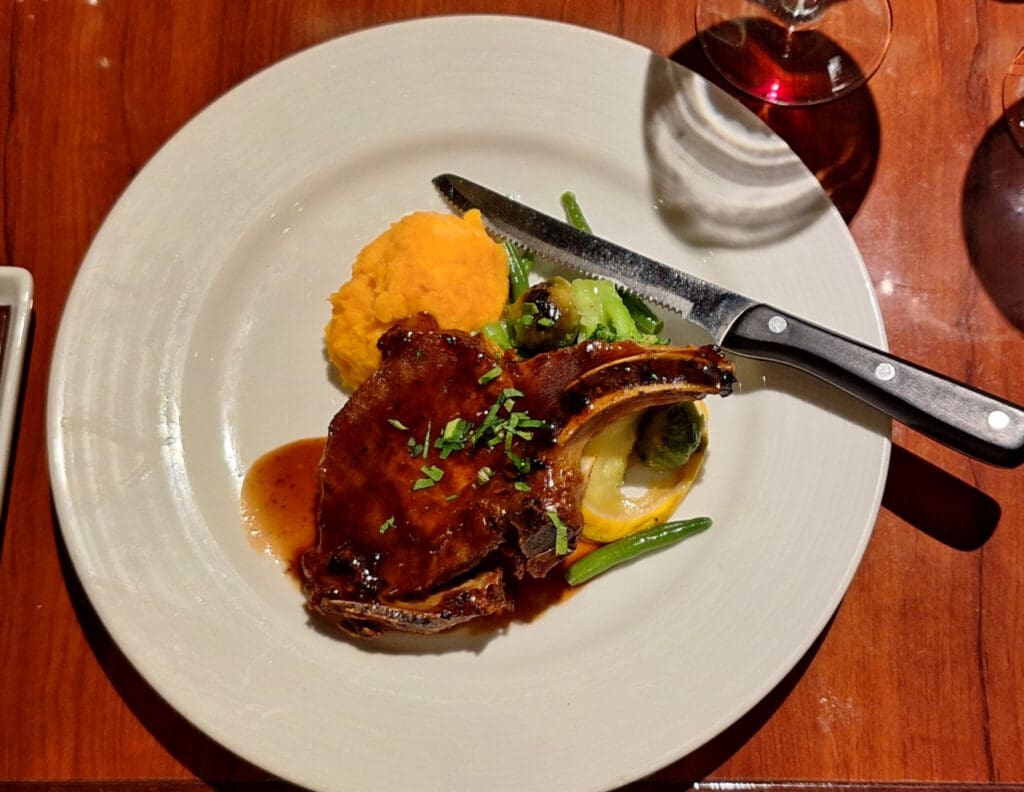 a plate of food with a knife and a glass of wine