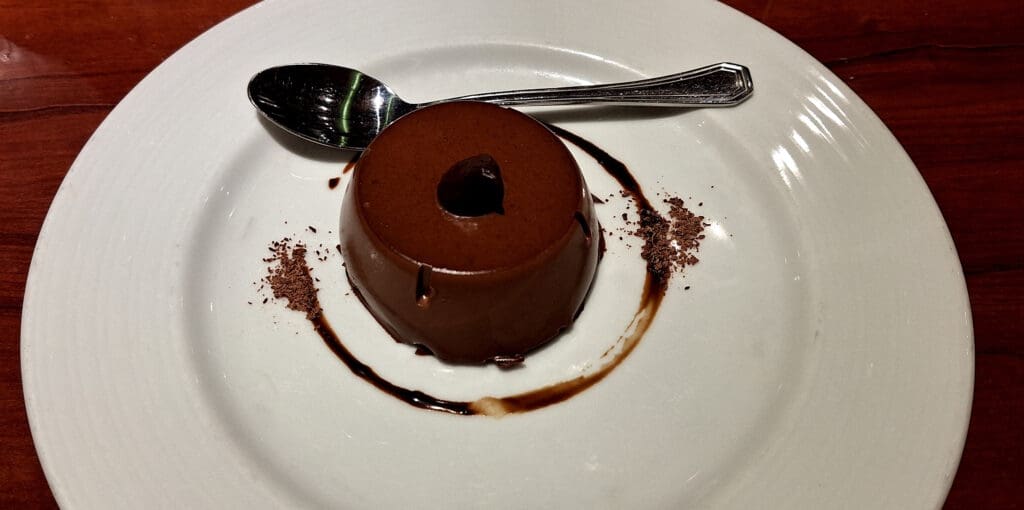 a chocolate pudding on a plate with a spoon