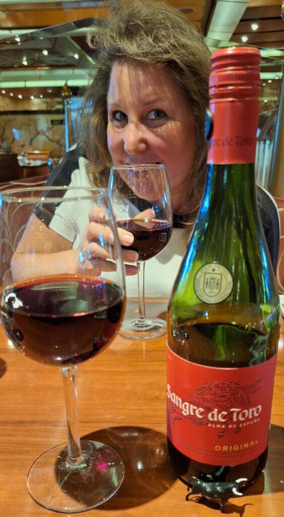 a woman drinking wine and holding a glass of wine