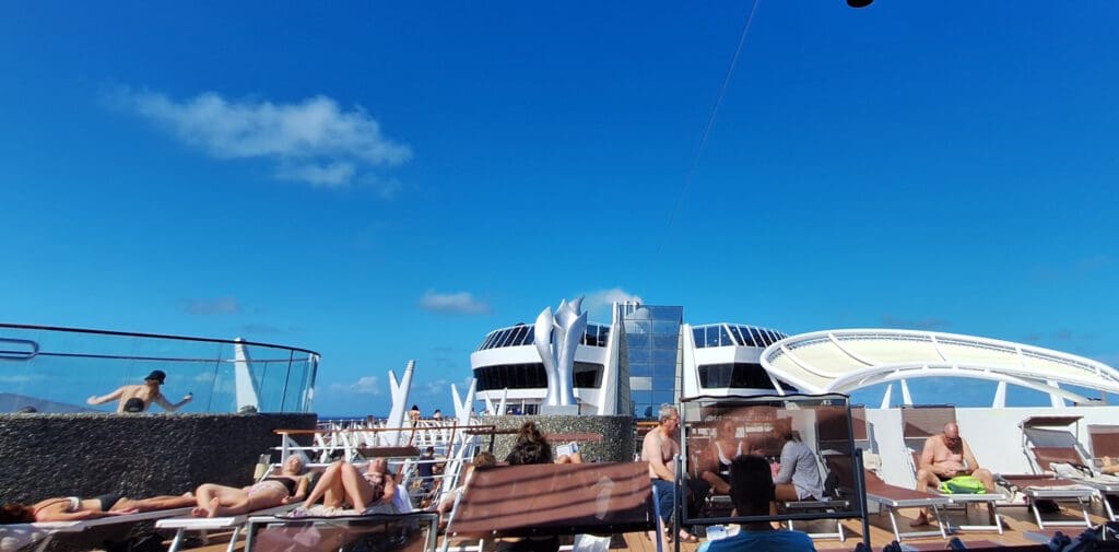 a group of people sitting on a deck of a cruise ship