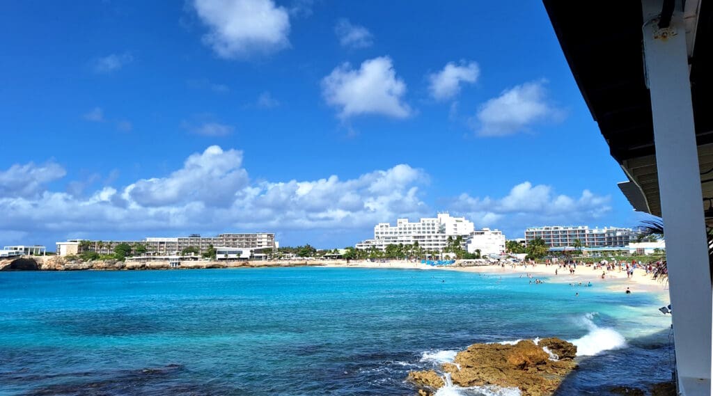 a beach with buildings and blue water