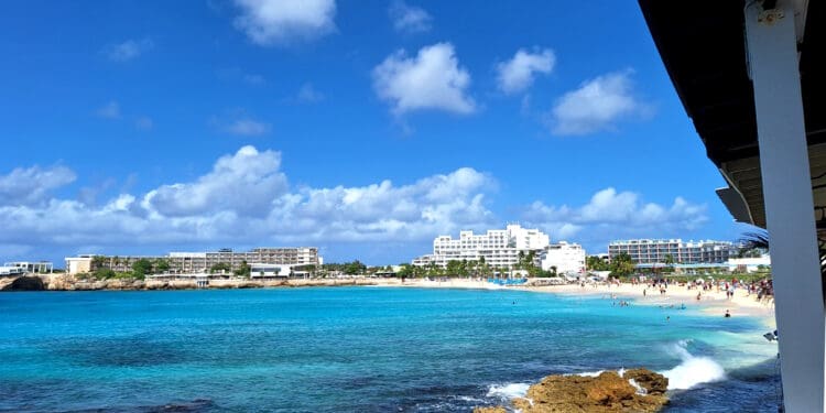 a beach with buildings and blue water
