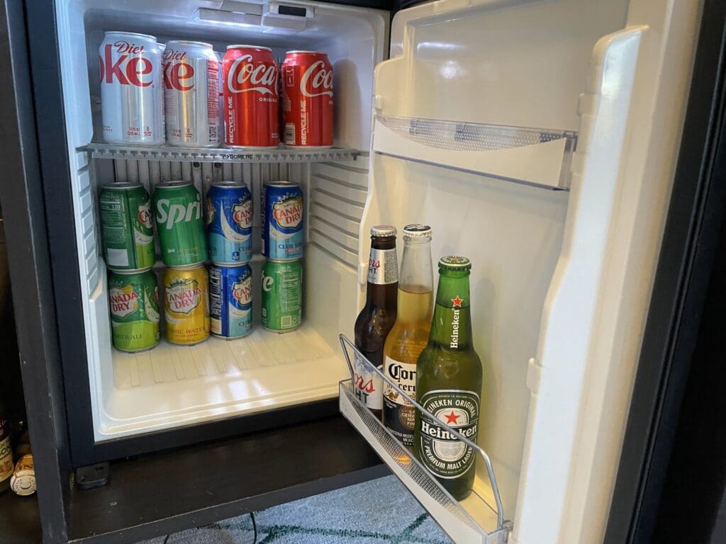 a refrigerator with cans of soda and cans of beer