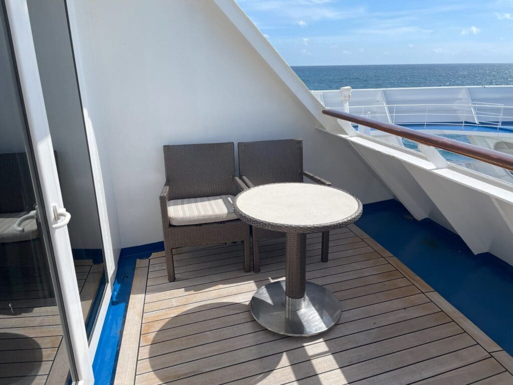 a table and chairs on a deck of a cruise ship