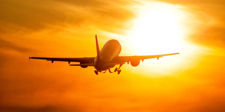 Take-off of a passenger airplane directly to the rising morning sun