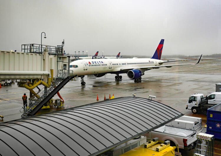 ATLANTA, GA, U.S.A. - JAN. 24, 2024: Taken from an indoor waiting area, a Delta airplane pulls up to a jetway at Hartsfield-Jackson International Airport. The airline is headquartered in Georgia.