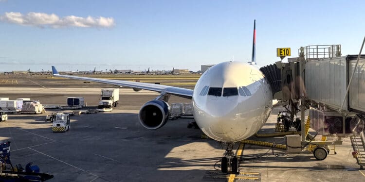 A Delta Air Lines Airbus A330-302, tail number N830NW, parks at Honolulu International Airport's gate E10.