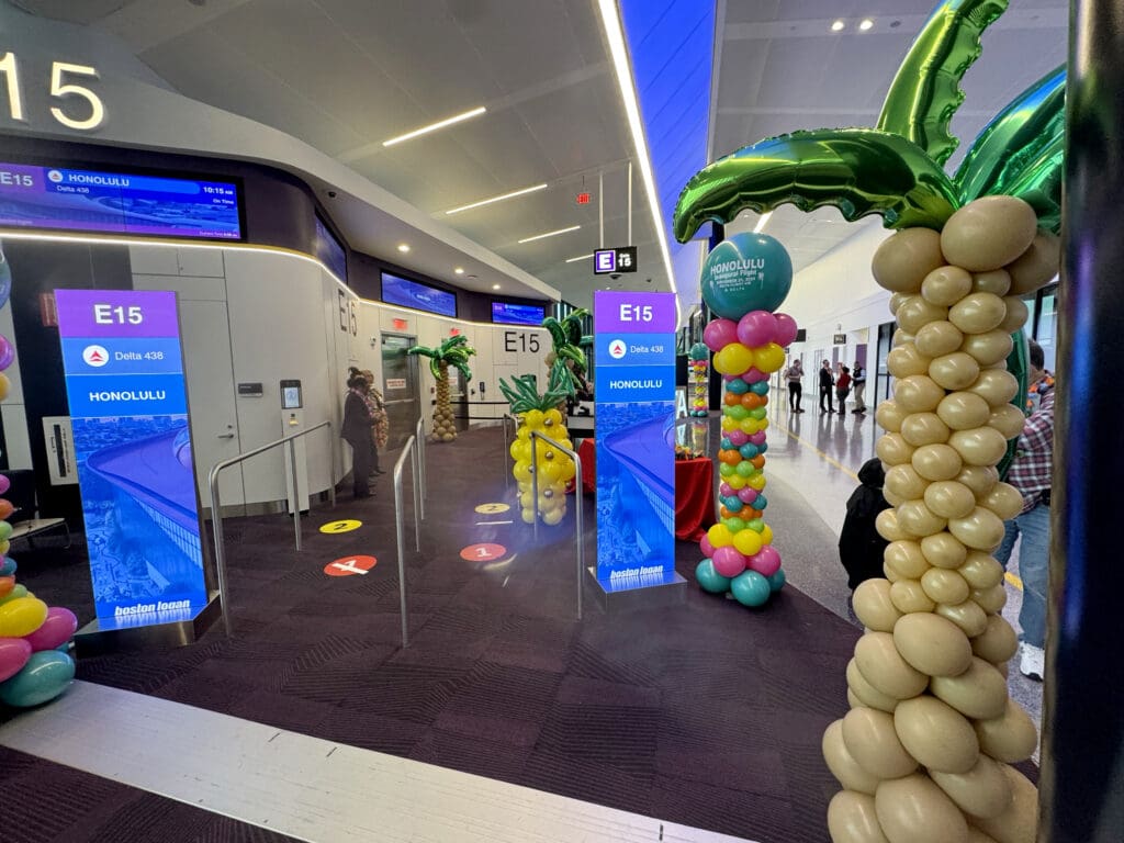 A balloon palm tree and balloon pineapple are seen at gate E15 during the party for Delta Air Lines’ inaugural flight from Boston (BOS) to Honolulu (HNL) at Boston Logan International Airport on Thursday, November 21, 2024. (©Eye of the Flyer)