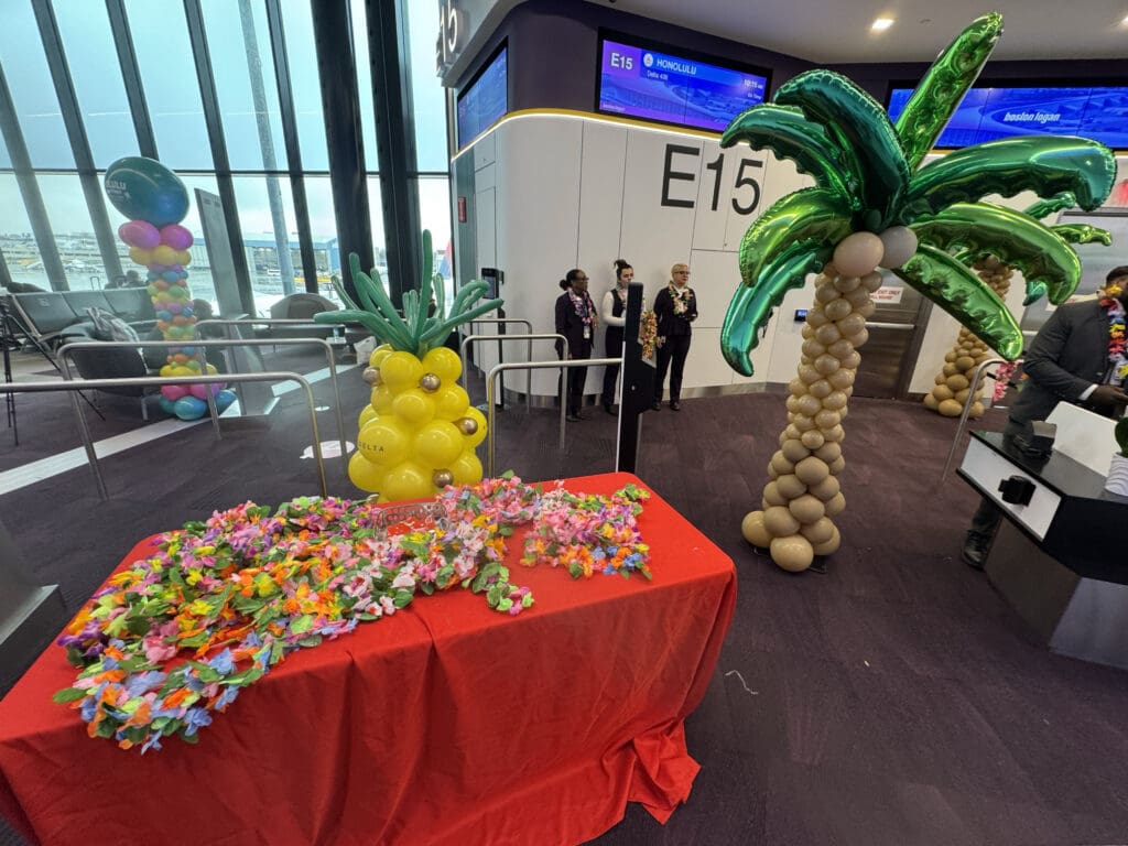 Imitation leis, a balloon palm tree, and a balloon pineapple are seen at gate E15 during the party for Delta Air Lines’ inaugural flight from Boston (BOS) to Honolulu (HNL) at Boston Logan International Airport on Thursday, November 21, 2024.