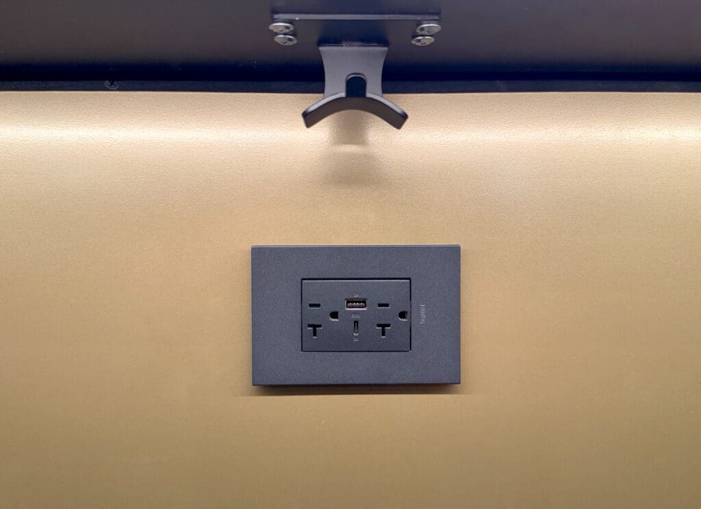 A hook for purses and other bags is installed above a power outlet at the Chase Sapphire Lounge's bar in San Diego.