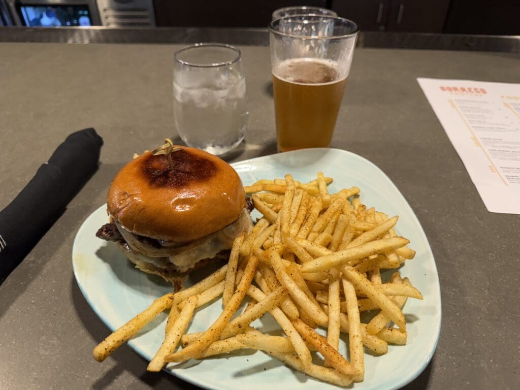 Smash burger, fries, and Athletic non-alcoholic IPA at Borrego Rooftop Kitchen + Cocktails atop the Hotel Indigo in San Diego, California. Borrego participates in the Resy program.