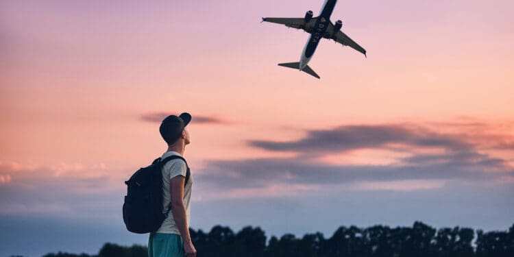 A man watches a Delta Air Lines plane depart.