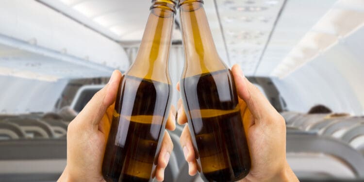 hands raised toasting with beer inside of an airplane