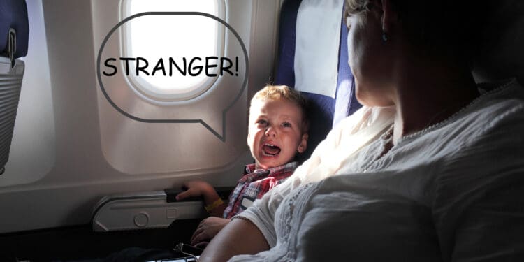 A little boy cries on an airplane, presumably because he's separated from his family.
