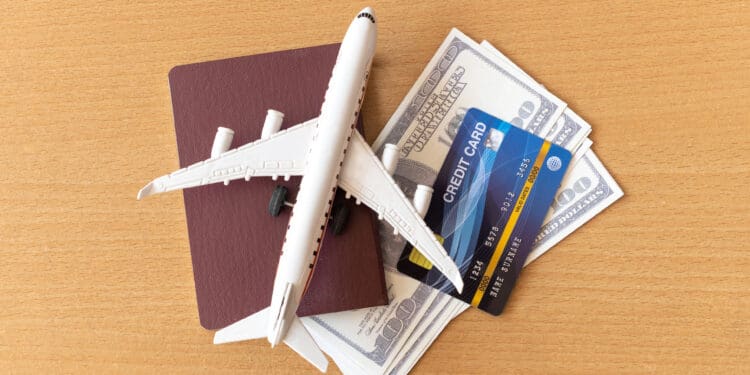 Toy airplane, credit cards, dollars and passport on wooden table. Travel concept