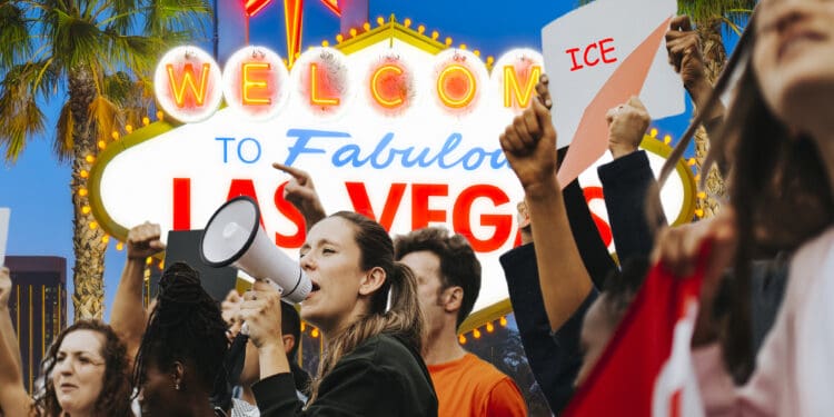 A group of people is gathered in front of the iconic "Welcome to Fabulous Las Vegas" sign. One person is speaking into a megaphone, while others hold up signs, one of which reads "ICE." The scene suggests a protest or demonstration, with palm trees and the bright lights of Las Vegas in the background.