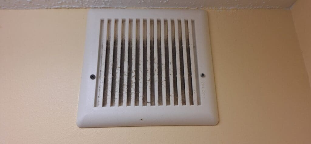 a white vent on a wall