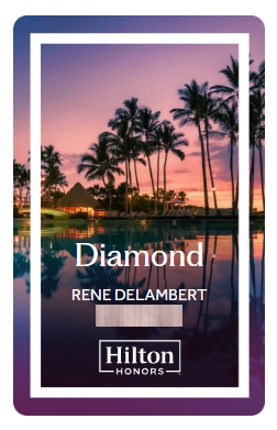 The image is a Hilton Honors membership card with a tropical background. The card features a sunset or sunrise scene with palm trees reflected in water. The text on the card reads "Diamond" and includes a name, "Rene Delambert," along with the Hilton Honors logo at the bottom.