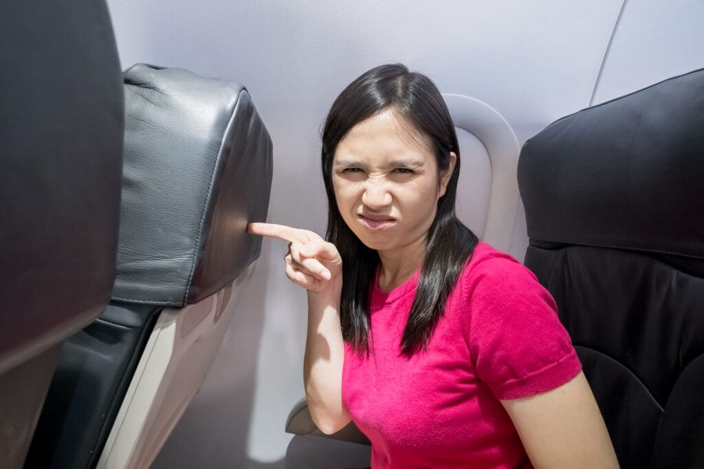 Woman upset because the passenger in front of her is reclining their seat.