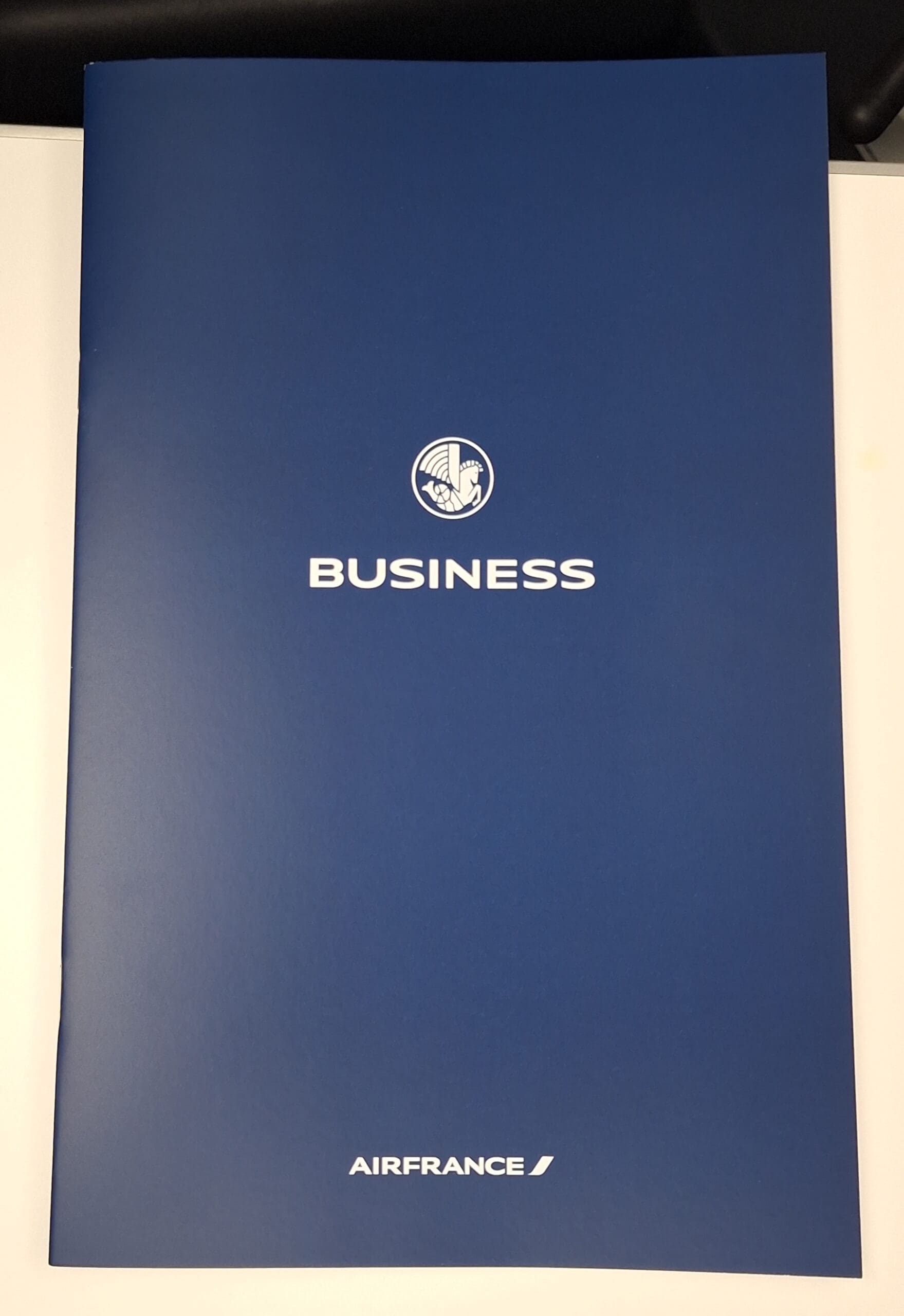 The image shows a blue folder with the word "BUSINESS" in white, accompanied by a logo above it. At the bottom, the text "AIRFRANCE" is displayed in white.