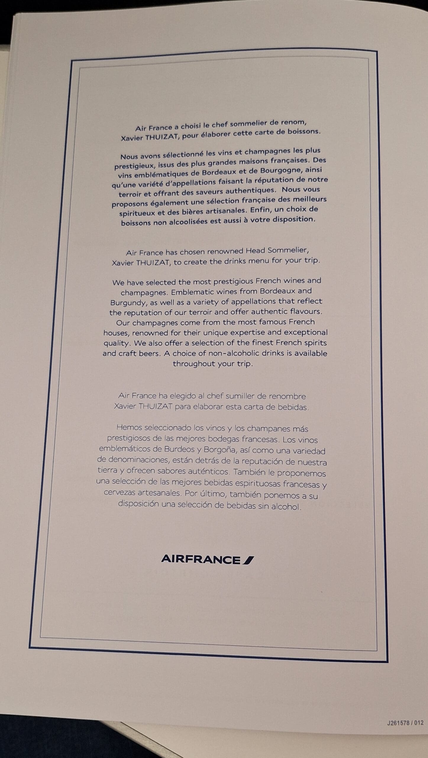The image shows a page from an Air France menu featuring text in French, English, and Spanish. It announces that Air France has chosen a renowned head sommelier, Xavier Thuizat, to create the drinks menu. The text highlights the selection of prestigious French wines and champagnes, including those from Bordeaux and Burgundy, and mentions a variety of appellations. It also notes the availability of French spirits, craft beers, and non-alcoholic drinks. The Air France logo is at the bottom.