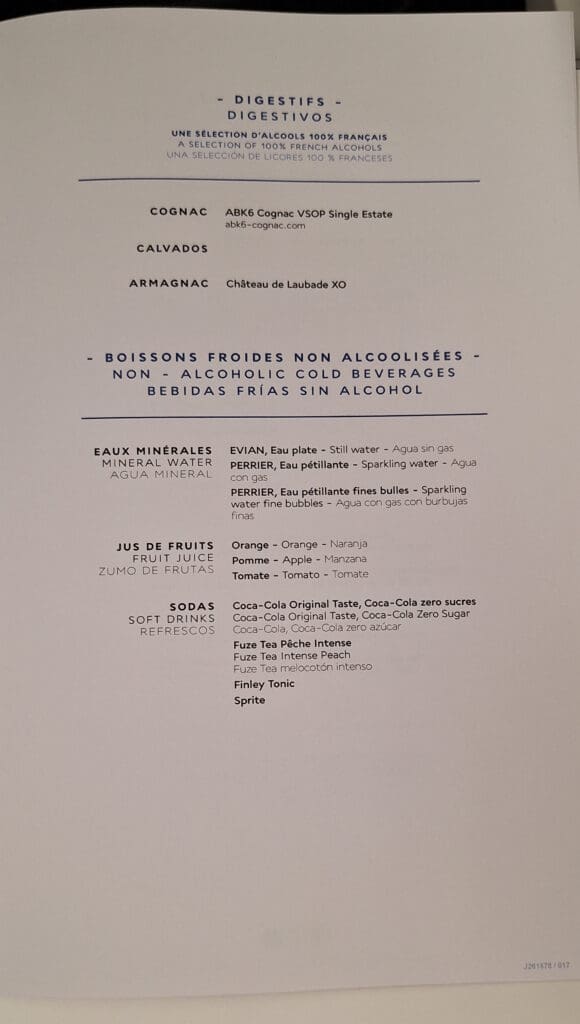 This image shows a menu listing digestifs and non-alcoholic cold beverages. The digestifs section includes options like ABK6 Cognac VSOP Single Estate, Calvados, and Château de Laubade XO Armagnac. The non-alcoholic beverages section lists mineral waters such as Evian and Perrier, fruit juices like orange, apple, and tomato, and sodas including Coca-Cola, Fuze Tea, Finley Tonic, and Sprite. The text is presented in French, English, and Spanish.