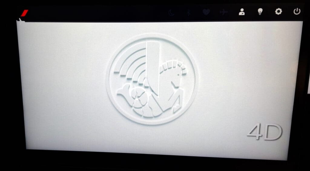 The image shows a white embossed logo on a light background. The logo features a stylized horse with a segmented tail, resembling a seahorse, and a large vertical shape that could be a sword or a shield. There are also curved lines above the horse, suggesting a wireless signal. In the bottom right corner, the text "4D" is visible. The top of the image has a black bar with various icons, including a red and white logo on the left.