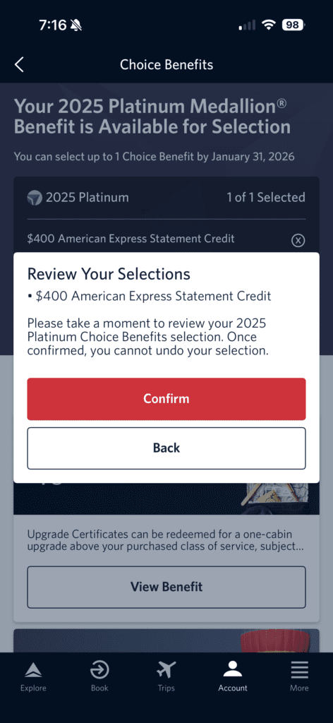 The image is a screenshot of a mobile app interface for selecting a 2025 Platinum Medallion® benefit. It shows a notification that the benefit is available for selection, with a deadline of January 31, 2026. The selected benefit is a $400 American Express Statement Credit. A pop-up window asks the user to review their selection, with options to "Confirm" or go "Back." The bottom of the screen has navigation icons labeled Explore, Book, Trips, Account, and More.