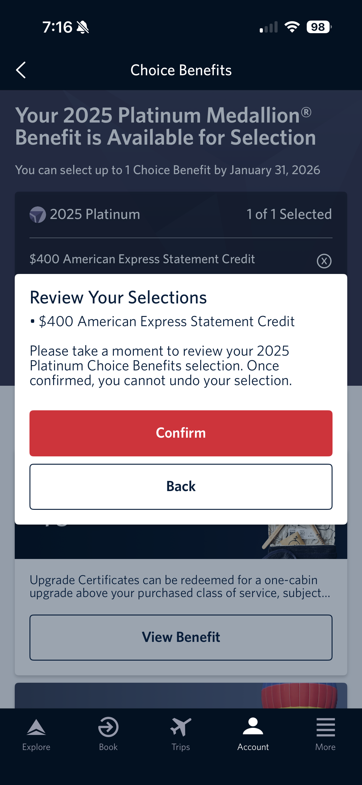 The image is a screenshot of a mobile app interface for selecting a 2025 Platinum Medallion benefit. It shows a notification that the benefit is available for selection, with a deadline of January 31, 2026. The selected benefit is a $400 American Express Statement Credit. A pop-up window asks the user to review their selection, with options to "Confirm" or go "Back." The bottom of the screen has navigation icons labeled Explore, Book, Trips, Account, and More.