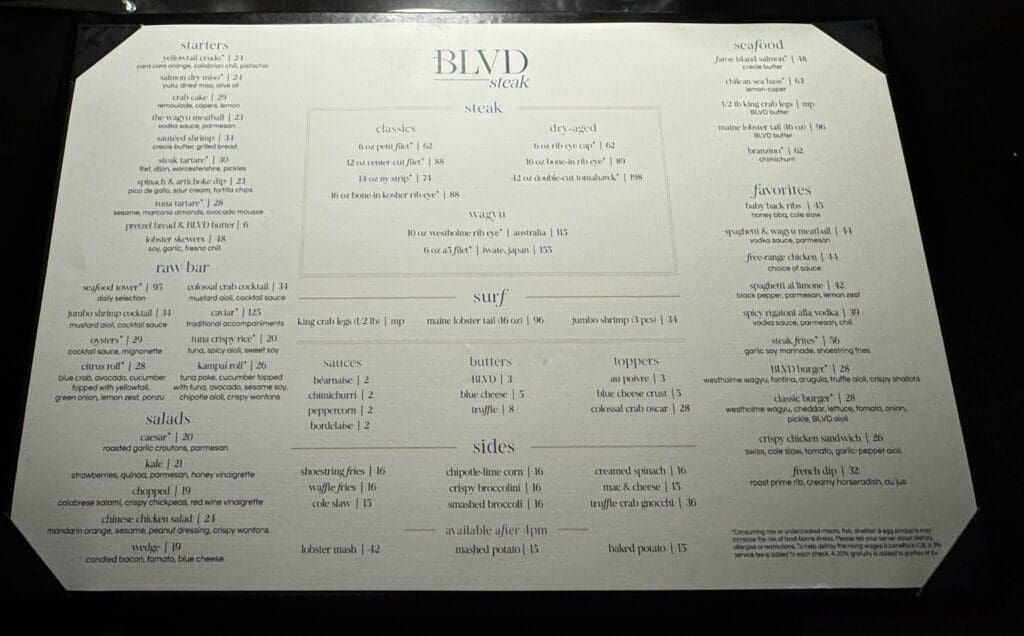 BLVD Steak in Calabasas, California. This image shows a restaurant menu titled "BLVD Steak." The menu is divided into several sections, including starters, raw bar, salads, steak, surf, seafood, favorites, sauces, butters, toppers, and sides. Each section lists various dishes with their ingredients and prices. The steak section includes options like classics, dry-aged, and wagyu. The menu also features a variety of seafood, salads, and side dishes.